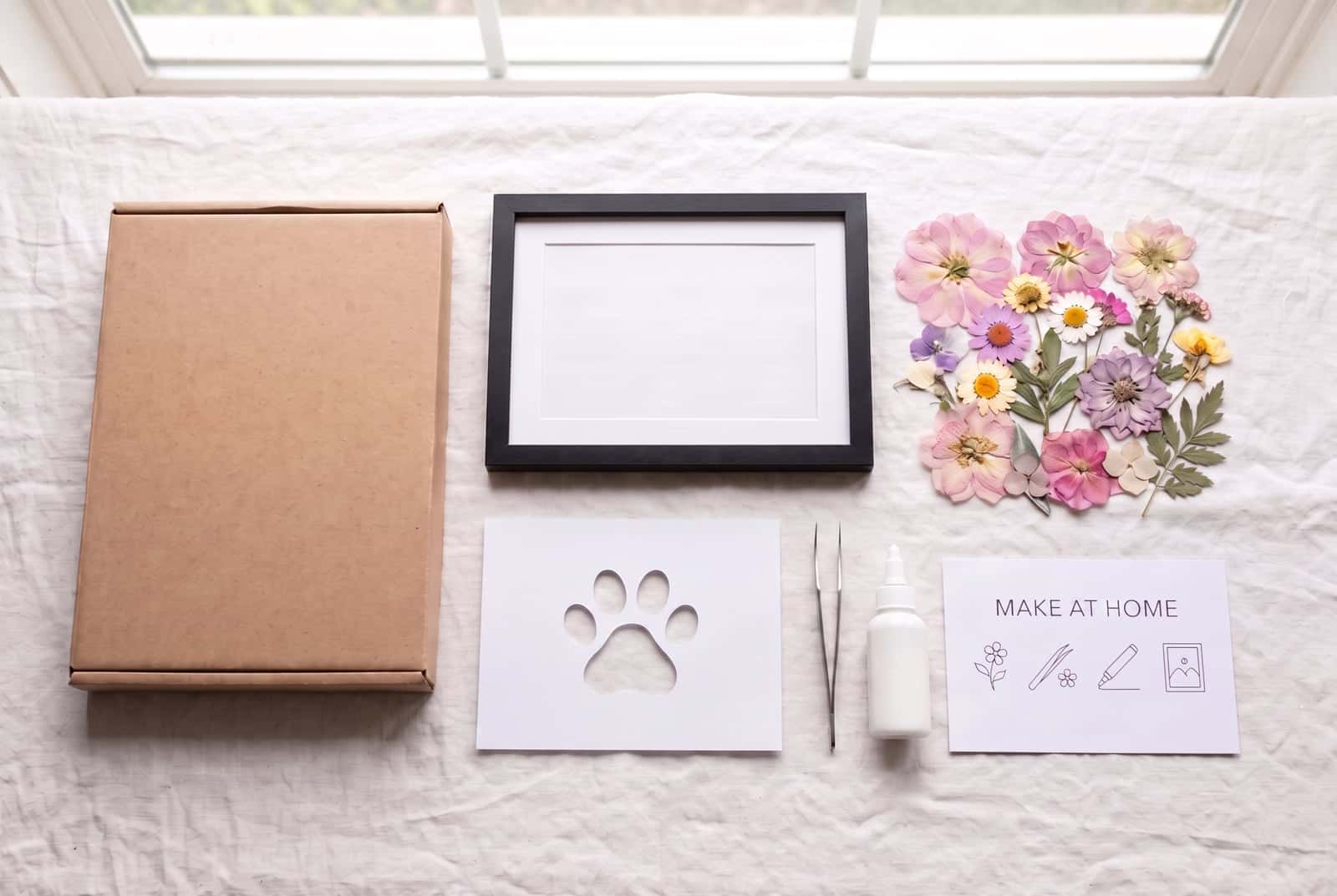 A pressed flower kit's contents and a completed framed piece